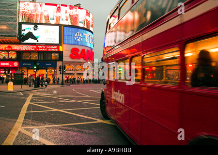 Bus und dem Piccadilly Circus Nachtleben Reflexionen im West End von London England Stockfoto