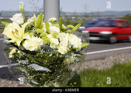 Tod auf den Straßen Auto beschleunigt vorbei ein floral Tribute Kennzeichnung der Stelle von einem tödlichen Verkehrsunfall Stockfoto