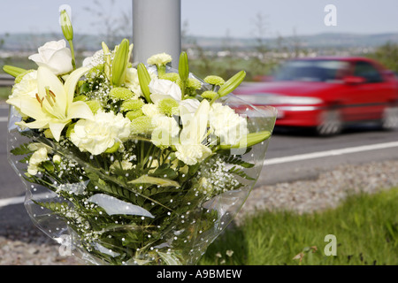 Tod auf den Straßen Auto beschleunigt vorbei ein floral Tribute Kennzeichnung der Stelle von einem tödlichen Verkehrsunfall Stockfoto