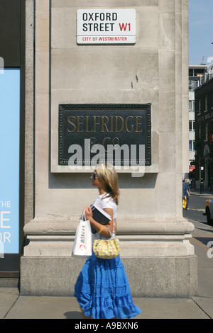 Eine weibliche Shopper geht vorbei an dem Schild für Selfridges in der Oxford Street, London, UK. 2006. Stockfoto