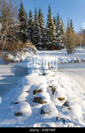 Verschneite Trittsteine über einen zugefrorenen Gartenteich, Finnland Stockfoto