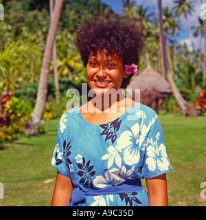 Fidschi Mädchen mit rosa Hibiskus Blume über ihrem linken Ohr im traditionellen Stil geblümten Kleid Matagi Insel der Fidschi-Inseln Stockfoto