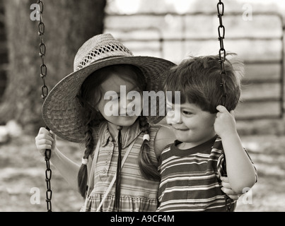 SOUTH CAROLINA YORK Bruder und Schwester mit ihre Arme umeinander auf eine altmodische Baum schwingen schwingen auf einem ländlichen Bauernhof Stockfoto