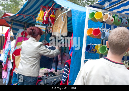 Kunden, die Kleidung zum Verkauf auf dem polnischen Balucki Rynek Bürgersteig Markt prüfen. Lodz Polen Stockfoto