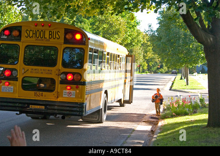 Boy wartet am Bordstein für Mama ihn abholen nach Schulbus fahren. St Paul Minnesota MN USA Stockfoto