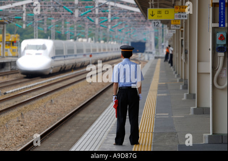 Ein Bahnhofsvorsteher befasst sich mit einem Shinkansen-Zug Aioi Station auf der Durchreise Stockfoto