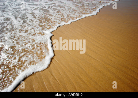 Ozean-Gezeiten oder Welle kommen, um einen Sandstrand Stockfoto