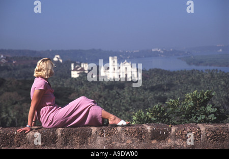 GOA, INDIEN. Eine junge Frau, Blick auf Old Goa in Richtung des Flusses Mandovi aus der Liebfrauenkirche des Berges. Stockfoto