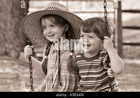 SOUTH CAROLINA YORK Bruder und Schwester mit ihre Arme umeinander schwingen auf einer alten altmodischen Baum Schaukel vor einem r Stockfoto