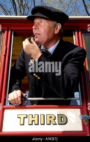 Richard Drewer lehnt sich aus einer Beförderung bläst Pfeife an waldigen Bucht Station auf der alten Bahntrasse von Lynton und Barnstaple zu schützen Stockfoto