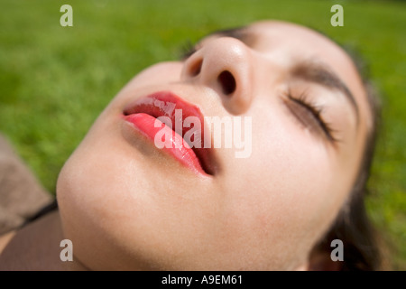 Gesicht des Mädchens auf dem Rasen mit geschlossenen Augen liegen Stockfoto