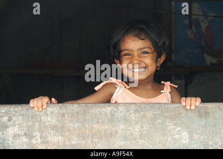 Ein junges Mädchen Lächeln für die Kamera in einem Rückstau-Dorf in der Nähe von Kochi (Cochin), Kerala, Südindien Stockfoto