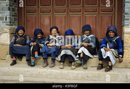 Sechs sehr alte Frauen sitzen auf einer Stufe in dem Dorf Baisha außerhalb Lijiang Yunnan Provinz Chinas zu sprechen Stockfoto