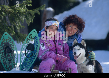 Frau, Siberian Husky und Mädchen auf Schlitten. Stockfoto