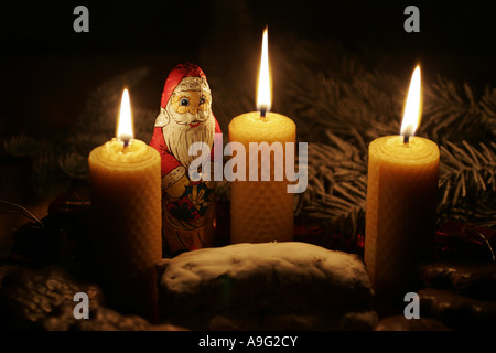 Schokolade-Weihnachtsmann im Schein der Kerzen aus Bienenwachskerzen Stockfoto