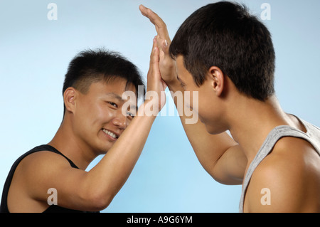 Zwei junge koreanische Männer Gruß Händeklatschen einander Teens Stockfoto