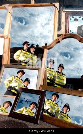 Zwei uniformierte Polizisten. eine männliche ein Weibchen, auf Fuß Patrouille spiegelt sich wieder im Spiegel in einem Schaufenster Stockfoto