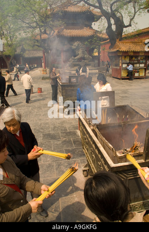 Der Lama-Tempel (Yonghe Gong) mit Gläubigen Räucherstäbchen in Räuchergefäße in der Nähe von Eingang platzieren Stockfoto