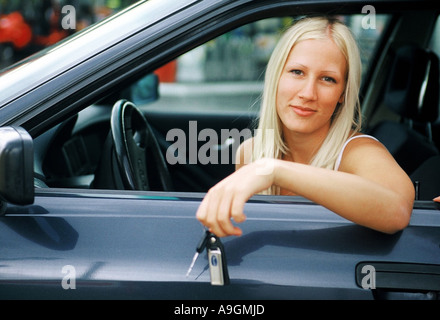 junge Frau sitzt in Automible, mit Schlüssel in der hand Stockfoto