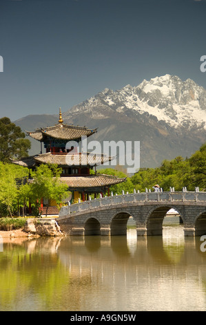 Lijiang der Black Dragon Pool mit Mond umarmen Pavillon und Belt-Brücke mit Jade Dragon Snow Mountain im Hintergrund Stockfoto