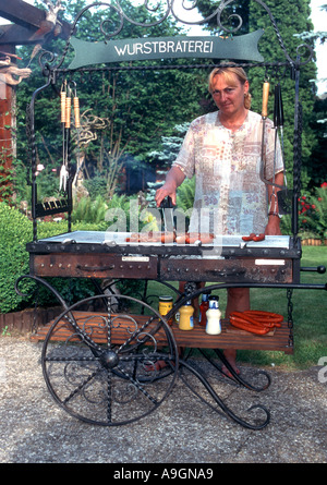 Frau Würstchen auf dem Grill im Garten Stockfoto