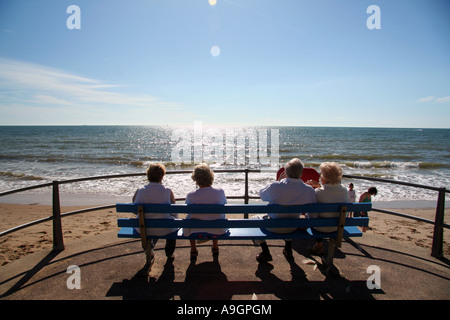 Paare auf Bank genießen Sie Sonne und Strand von Bournemouth Stockfoto