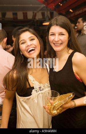 Zwei Mädchen posiert für die Kamera auf eine Nacht in einem belebten Londoner bar Stockfoto