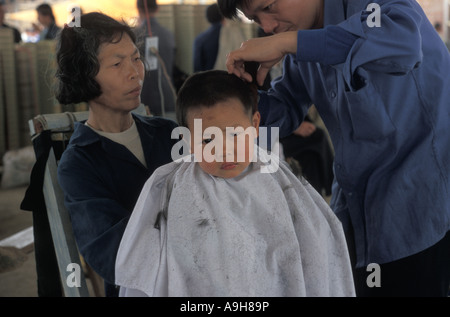 Kleiner Junge reinkommen Fuli China nahe Yangshou Haarschnitt im Open market Stockfoto