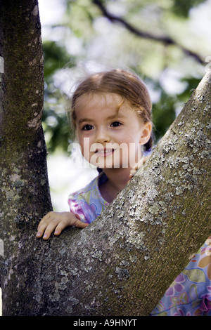 SOUTH CAROLINA YORK schönes junges Mädchen mit Zöpfen blickt in die Ferne, als sie träumt, während eine Mimose Kletterbaum Stockfoto