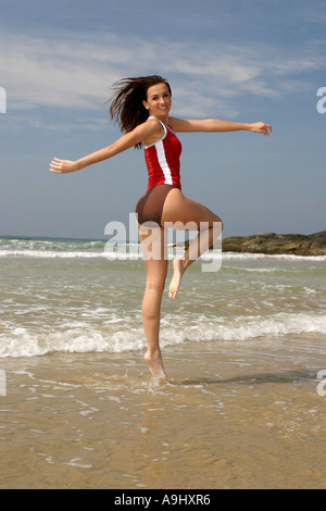 Frau am Strand, springen tragen rote T-shirt und Shorts. Stockfoto