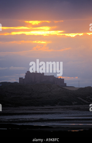 SONNE GOING DOWN ÜBER BAMBURGH CASTLE IN NORTHUMBERLAND, ENGLAND, VEREINIGTES KÖNIGREICH Stockfoto