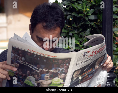 Mann liest Sonntagszeitung im Les Deux Magots Cafe Paris France Stockfoto