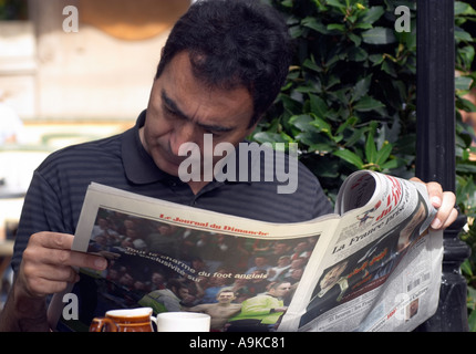 Mann liest Sonntagszeitung im Les Deux Magots Cafe Paris France Stockfoto