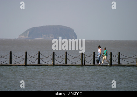 Menschen auf dem Gehweg über die Meeres-See in Weston Super Mare mit steilen Holm Insel in der Ferne Stockfoto