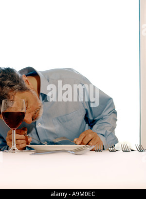 mittleren gealterten männlichen Blick auf Lebensmittel auf Teller im restaurant Stockfoto