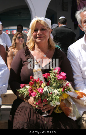 Frau hält einen Blumenstrauß in der La Griba Synagoge Djerba während des Festivals Lag B'Omer Stockfoto