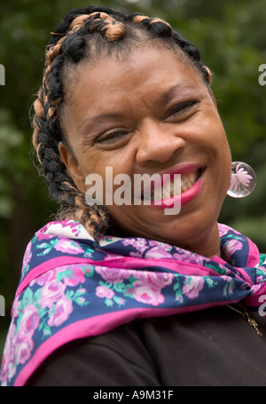 Glückliche Afroamerikanerin, die einen farbenfrohen Schal trägt und draußen lächelt. USA. Stockfoto