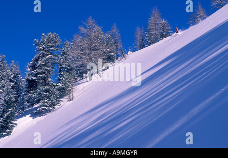 Einsamer Skifahrerin kommen bergab auf unberührten Tiefschnee im Bereich Chamonix in den französischen Alpen Stockfoto