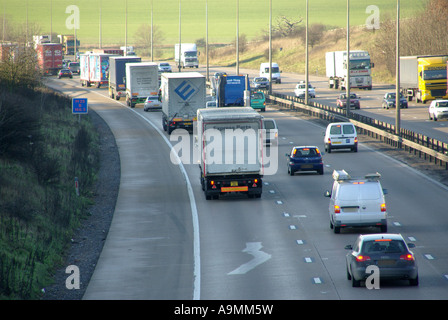 LKW-LKW-Lieferkette htgv Fahrzeuge verlangsamen mit Autos & Vans im langsamen Verkehr M25 dreispurige Autobahn wurde später vier Spuren Essex England Großbritannien Stockfoto