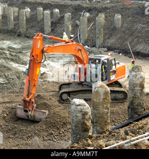 Auf Gebäude Baustelle Mechanische Bagger Bagger arbeiten rund um Beton Bohrpfähle Vorbereitung Keller Erdarbeiten London UK Stockfoto