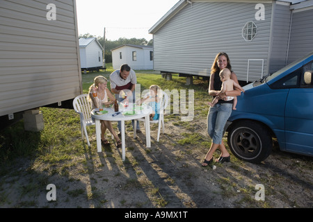 Blauen Kragen Familien genießen eine Grillparty vor Anhänger Haus Stockfoto