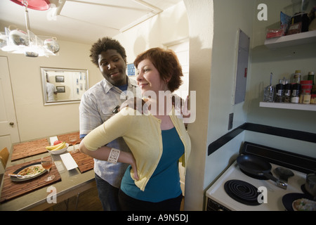 Inter-racial Brautpaar posiert liebevoll durch ihre Küche Stockfoto