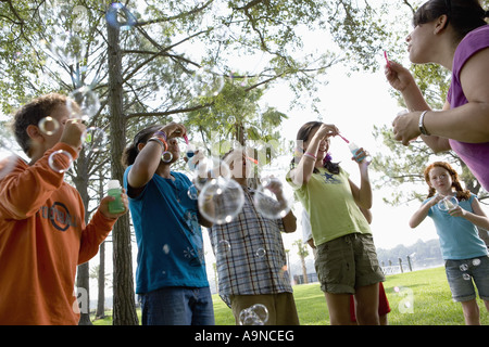 Kinder und ihr Lehrer Seifenblasen in einem park Stockfoto