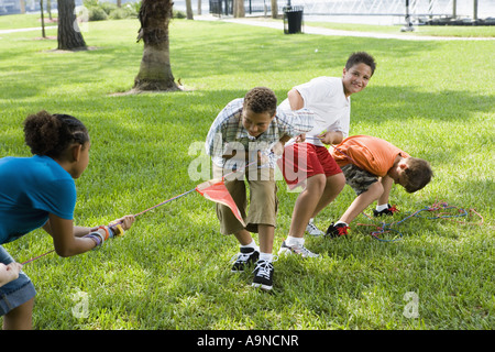 Drei jungen und ein Mädchen zog hart an ein Tauziehen Stockfoto