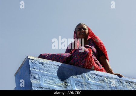 Frau sitzt auf der Wand des Hauses in die "Blaue Stadt" von Jodhpur, Rajasthan, Indien. Stockfoto