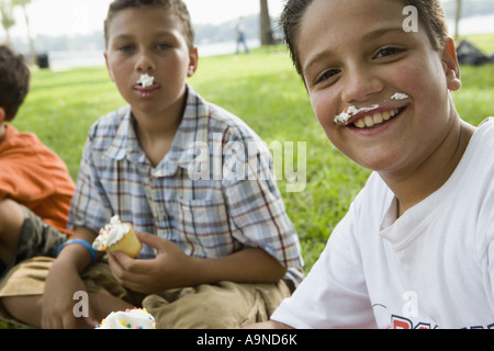 Jungen, die Cupcakes zu essen, in einem park Stockfoto