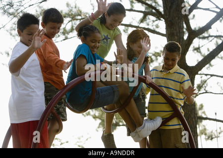 Jungen und Mädchen Klettern am Klettergerüst auf einem Spielplatz Stockfoto