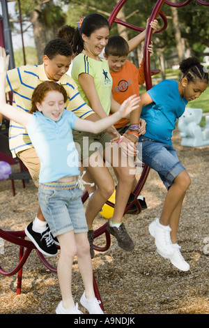 Jungen und Mädchen abspringen Klettergerüst auf einem Spielplatz Stockfoto