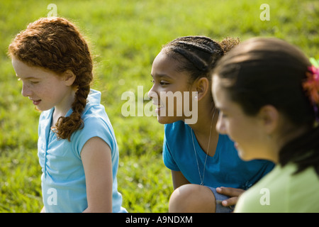 Drei Mädchen sitzen zusammen auf dem Rasen Stockfoto