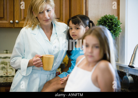 Mutter mit Töchtern in der Küche stehen Stockfoto